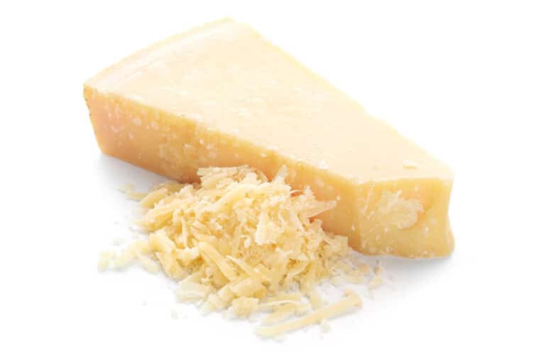 A slice of parmesan cheese, some of which has been grated